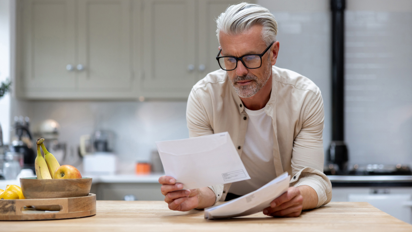 Man reviewing documents in modern kitchen
