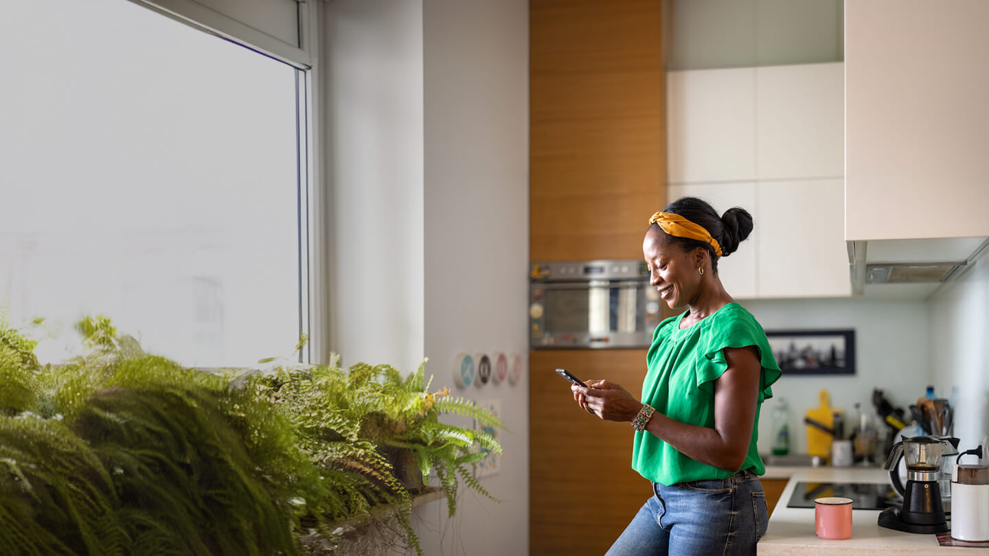 person looking at phone in kitchen